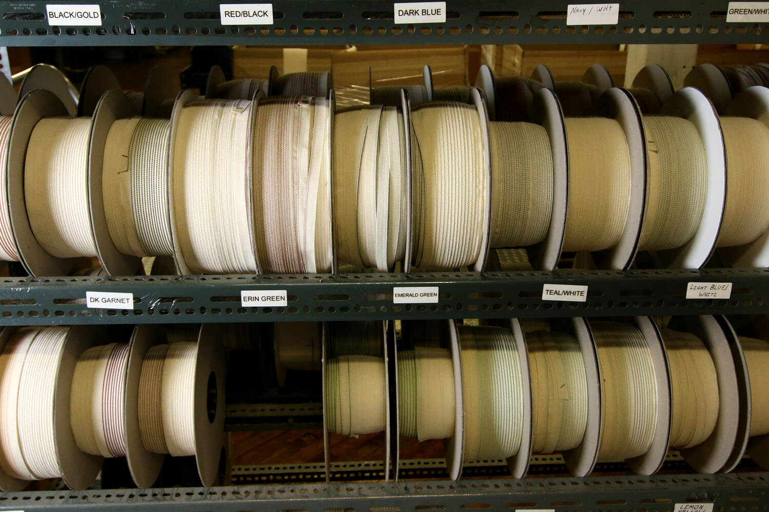 Multiple rolls of fabric stored and categorized by color